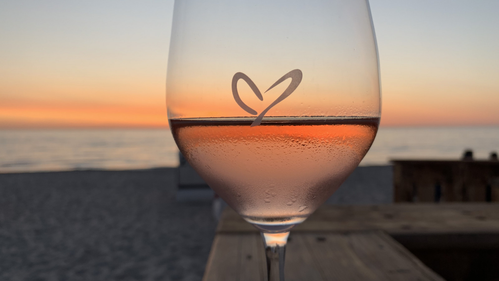 Weinglas mit Herz bei Sonnenuntergang an der Strandbude des Strandhotel Fischlands