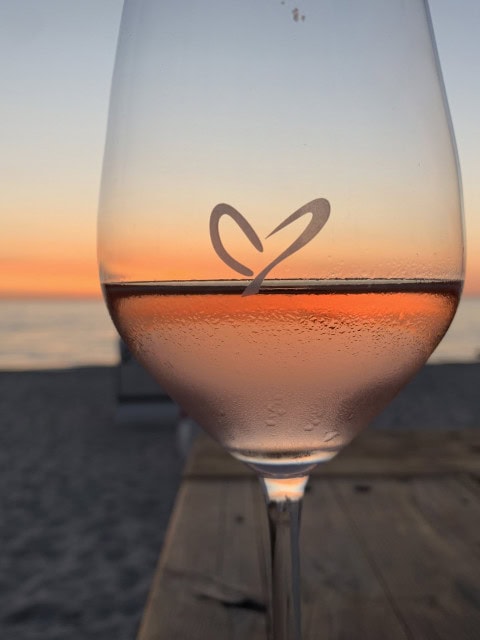 Weinglas mit Herz bei Sonnenuntergang an der Strandbude des Strandhotel Fischlands