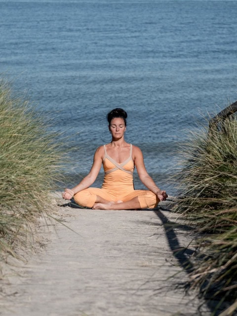 Yogalehrerin in den Dünen des Strandhotel Fischlands