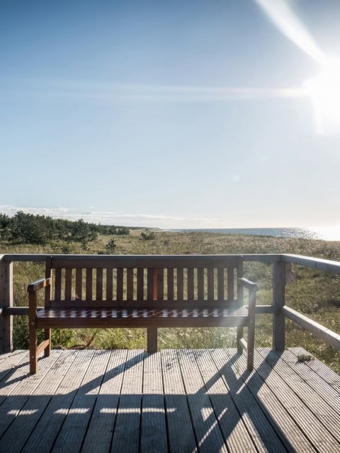 Strandhotel Dünenmeer aus der Ferne mit einer Holzbank im Vordergrund