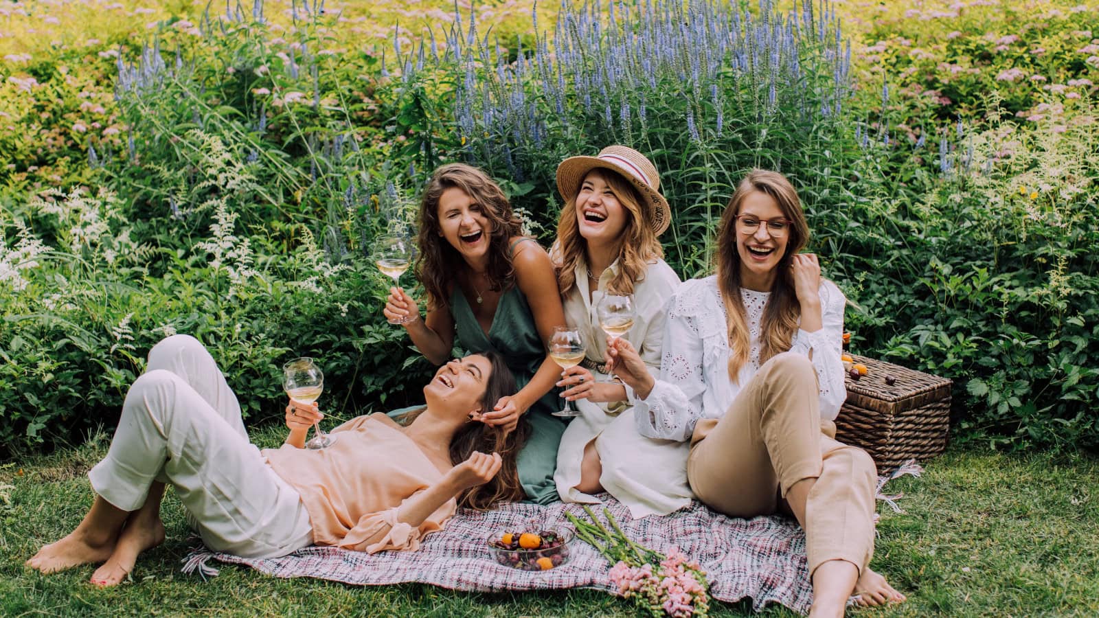 Freundinnen beim Picknick mit Wein und Obst