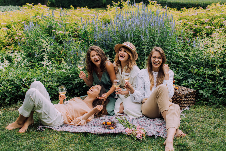Freundinnen beim Picknick mit Wein und Obst