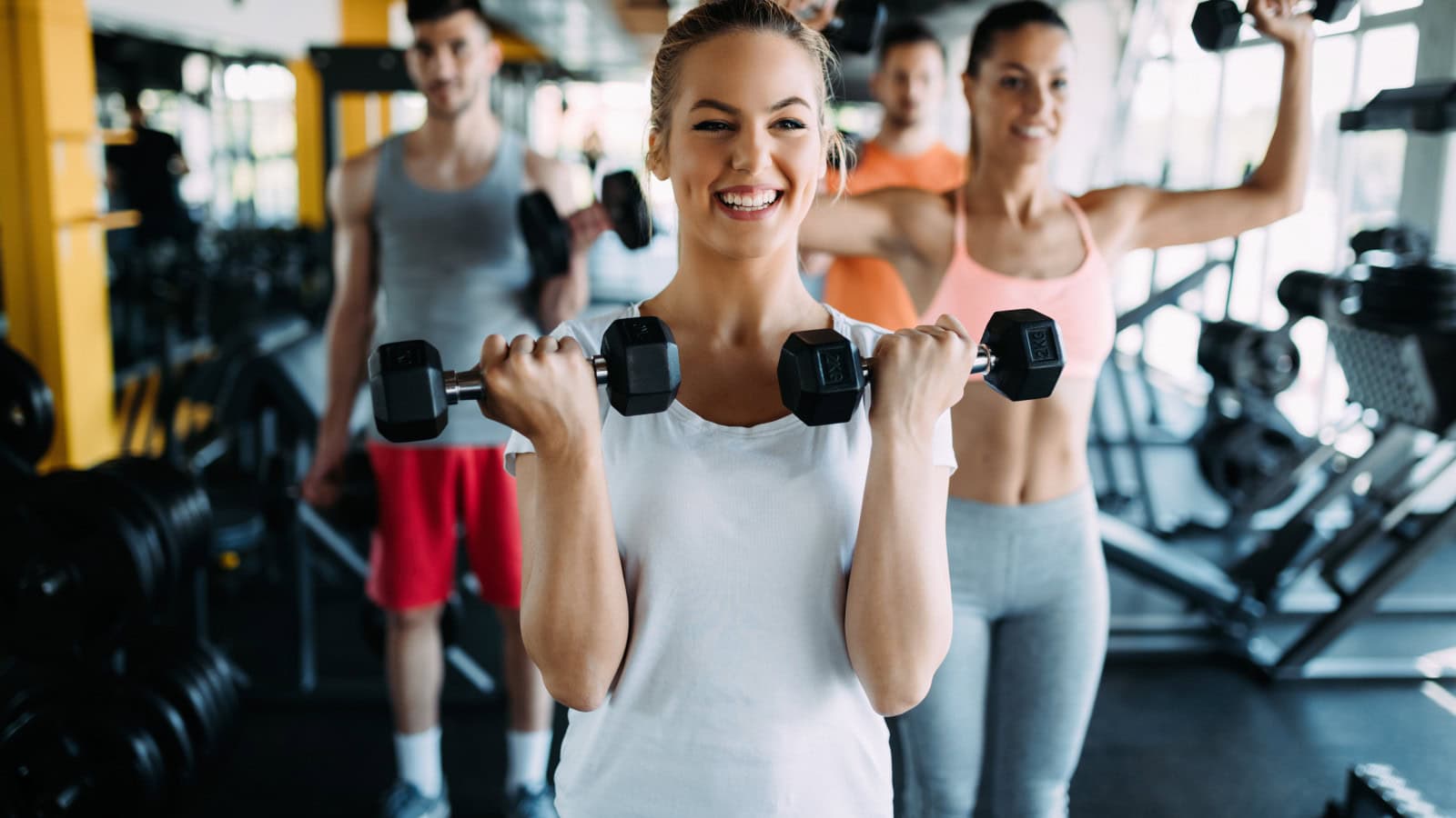 Junge Frauen und Männer beim Sport im Fitnessstudio