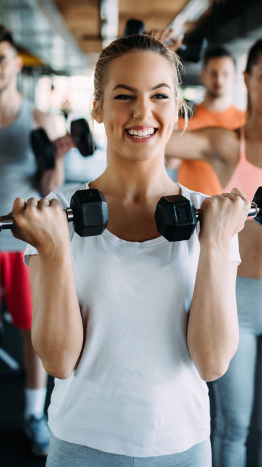 Junge Frauen und Männer beim Sport im Fitnessstudio