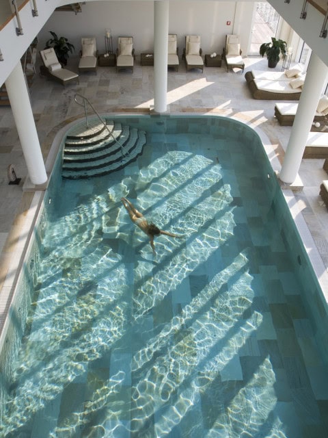 Frau schwimmt im Indoorpool im Strandhotel Dünenmeer