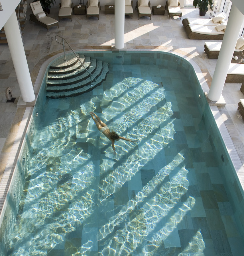Frau schwimmt im Indoorpool im Strandhotel Dünenmeer
