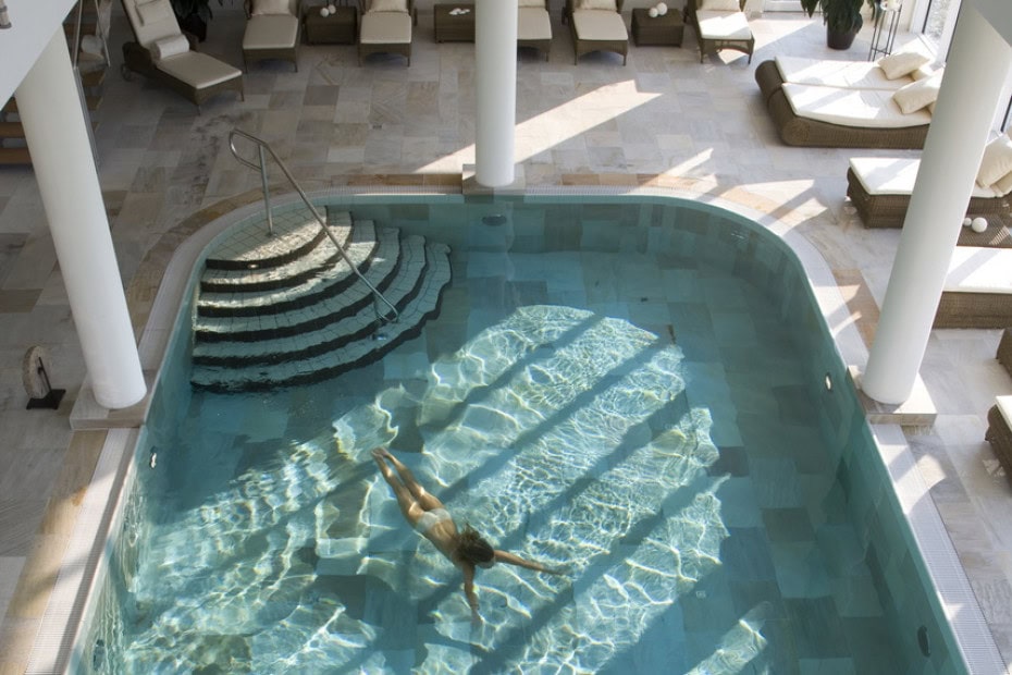 Frau schwimmt im Indoorpool im Strandhotel Dünenmeer