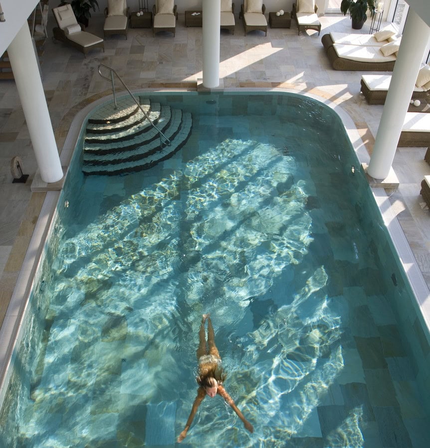 Frau schwimmt im Indoorpool im Strandhotel Dünenmeer