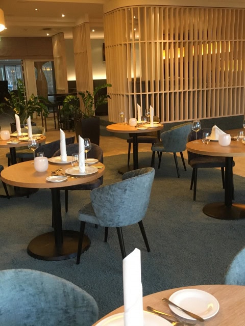 eingedeckte Tische in der Kaminlounge im Strandhotel Dünenmeer