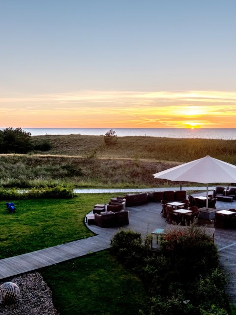 Dünenterrasse im Strandhotel Dünenmeer bei Sonnenuntergang