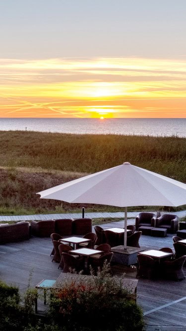 Dünenterrasse im Strandhotel Dünenmeer bei Sonnenuntergang
