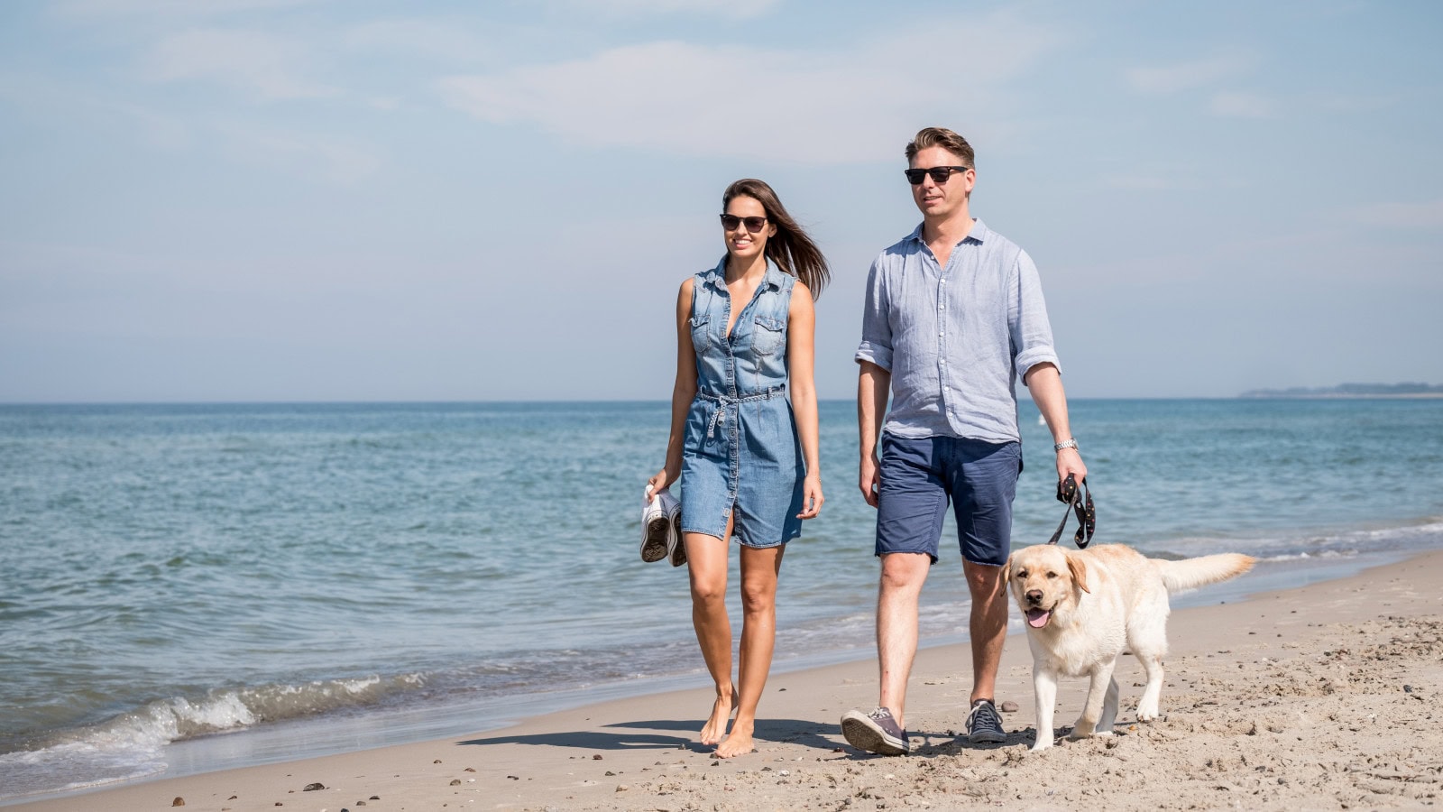 Paar mit Hund am Ostseestrand beim Strandhotel Dünenmeer