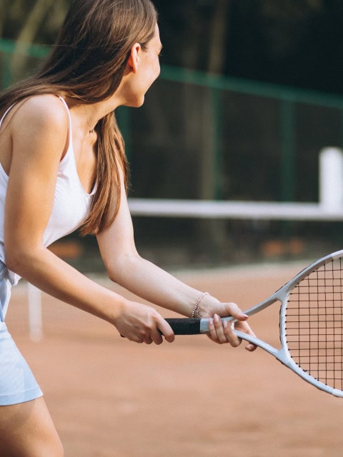 Junge Dame beim Tennisspielen im Strandhotel Fischland